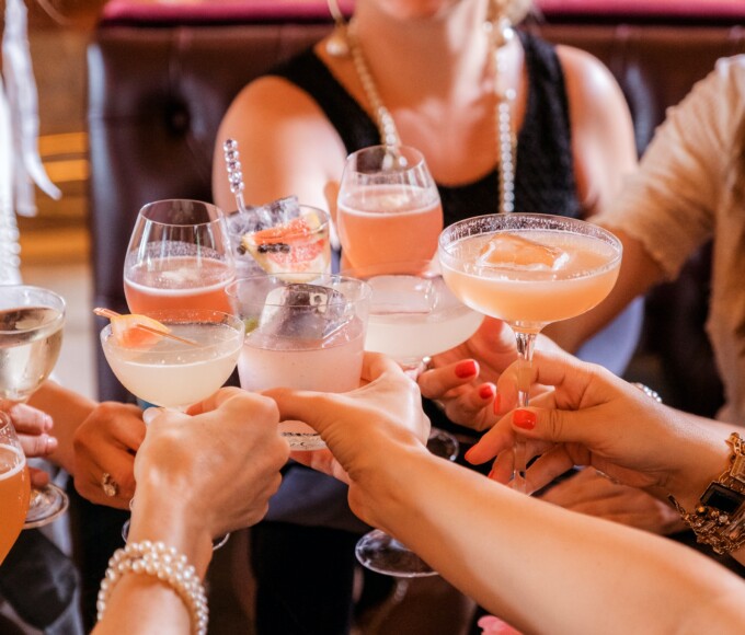 group of people cheering with cocktails