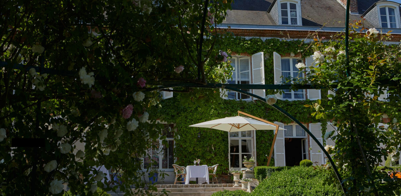 Spirites stories outdoor home covered in wildlife and flowers with table for dining