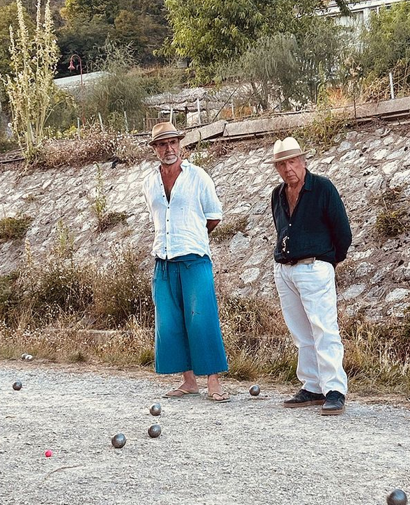 two men playing game of bowls wearing hats