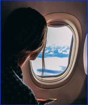 woman looking out an airplane window