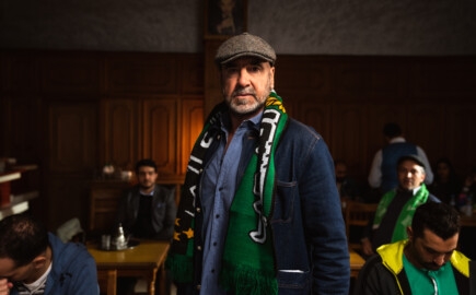 Man wearing scarf and cap in pub