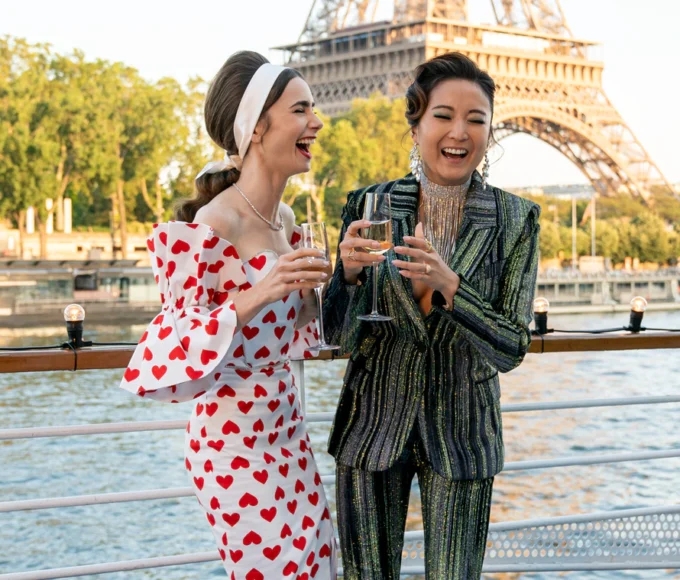 Emily in paris image of lily collins and friend drinking champagne by Eiffel tower