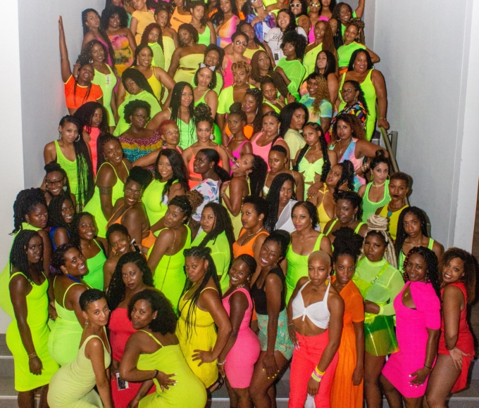 Group of women dressed in bright colours posing for photo